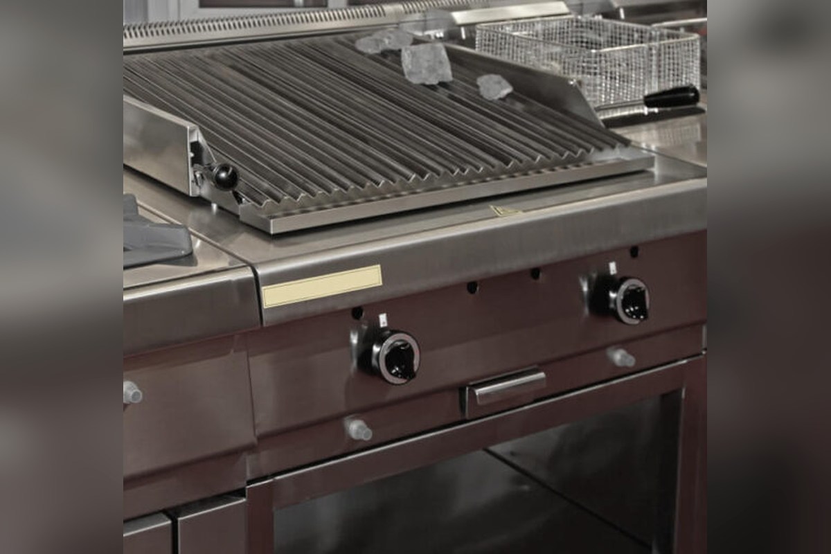 Large stainless steel commercial gas range with multiple burners and a grill plate